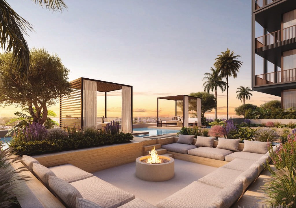 Sunken seating around a firepit, cabanas and palms at sunset
